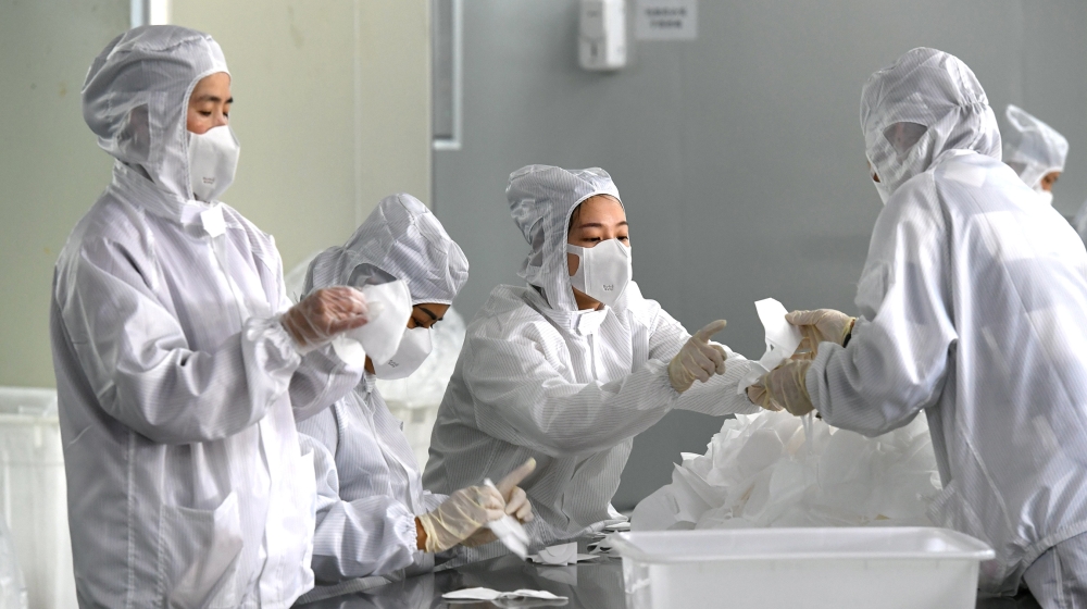 Employees work on a production line manufacturing face masks at a factory, as the country is hit by an outbreak of the novel coronavirus, in Fuzhou, Fujian province, China February 15, 2020. cnsphoto