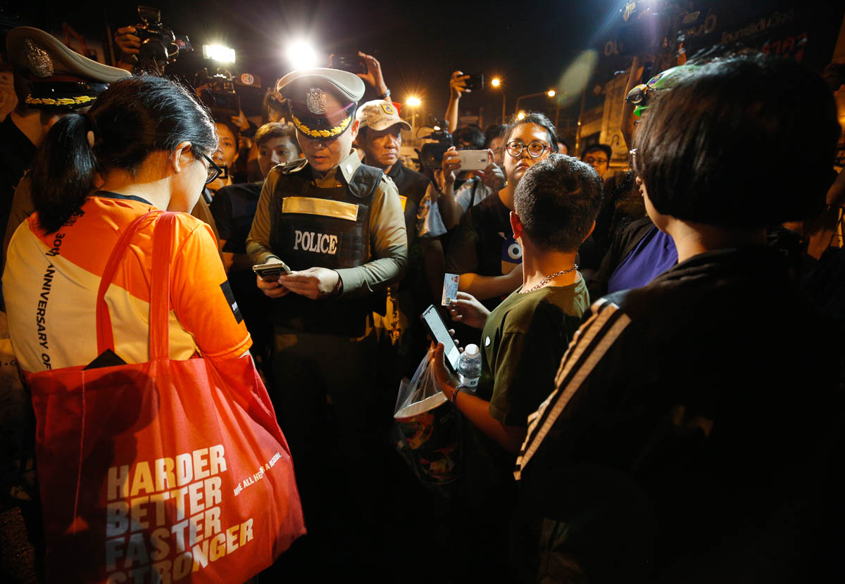 epa08203893 Thai police officer (C) stands with some rescued people as he checks the list of people still trapped within the incident, after a suspected Thai soldier opened fire in a rampage at the Te
