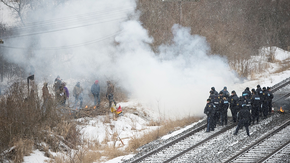 Ontario police douse flames lit on Canadian National Railway tracks near an encampment of Tyendinaga Mohawk land defenders, set up in support of Wet’suwet’en hereditary chiefs who are trying to stop construction of British Columbia’s Coastal GasLink pipeline