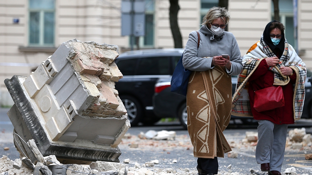 Women walk past ruins of a building following an earthquake, in Zagreb, Croatia March 22, 2020. REUTERS/Antonio Bronic