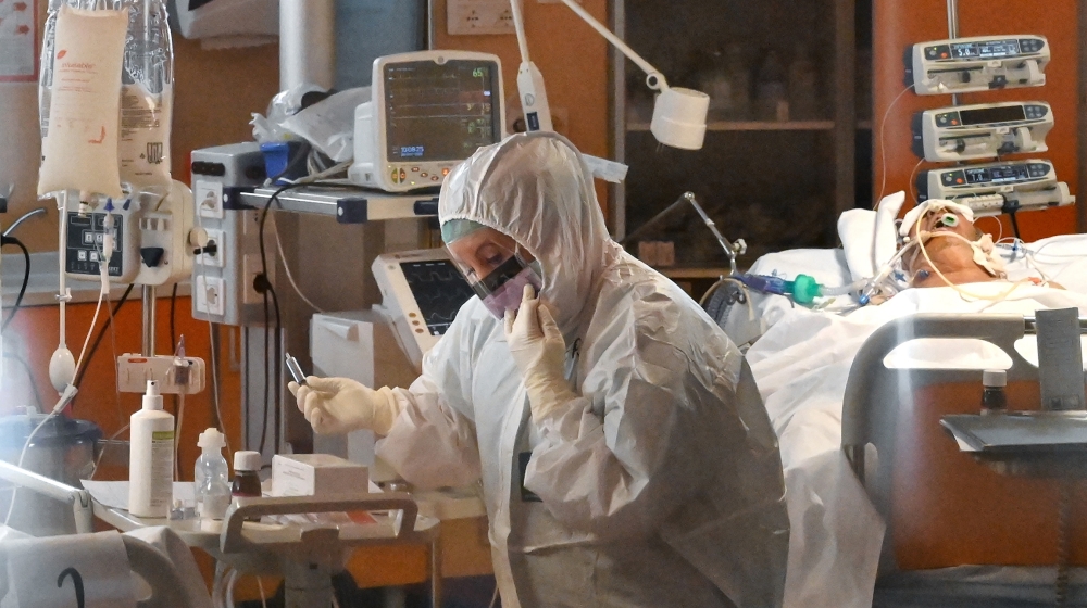 A medical worker wearing a protective gear works by a patient (Rear R) on March 24, 2020 at the new COVID 3 level intensive care unit for coronavirus COVID-19 cases at the Casal Palocco hospital near