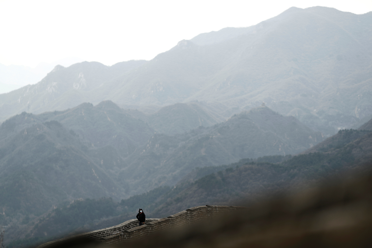 A person wearing a protective mask hikes along a section of the Great Wall in Badaling in Beijing, on its first day of re-opening after the scenic site''s coronavirus related closure, China, March 24,