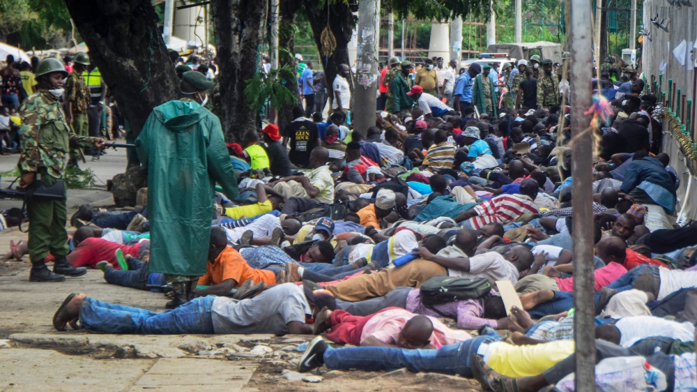 Police force ferry passengers to lie face down on the ground after firing tear gas and detaining them, after new measures aimed at halting the spread of the new coronavirus instead caused a crowd