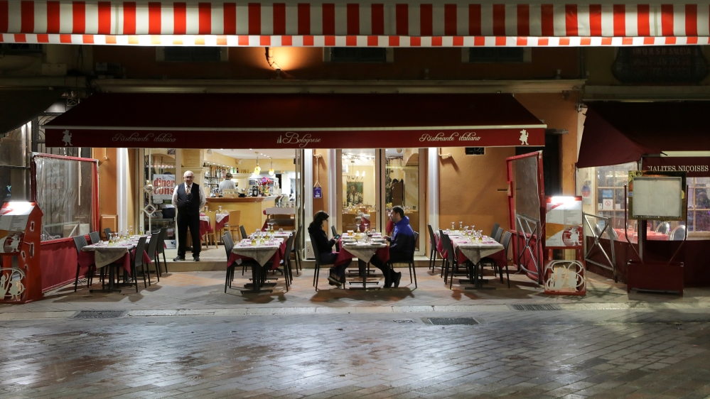 A couple sits in a restaurant, as France's Prime Minister announced to close most all non-indispensable locations, notably cafes, restaurants, cinemas, nightclubs and shops from midnight in Nice