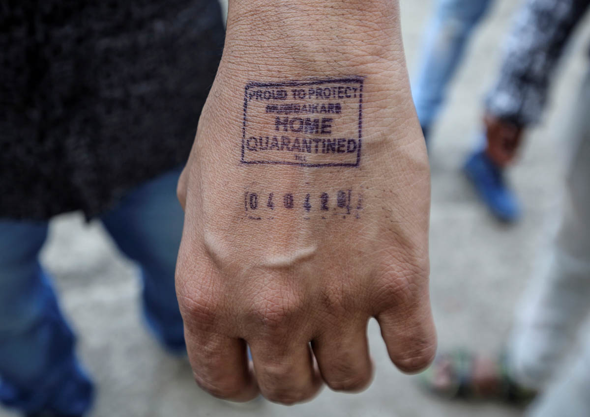 A man shows his hand which was stamped by airport authorities as he was advised for home quarantine after he arrived from overseas, amid coronavirus disease (COVID-19) fears, in Mumbai, India, March 2