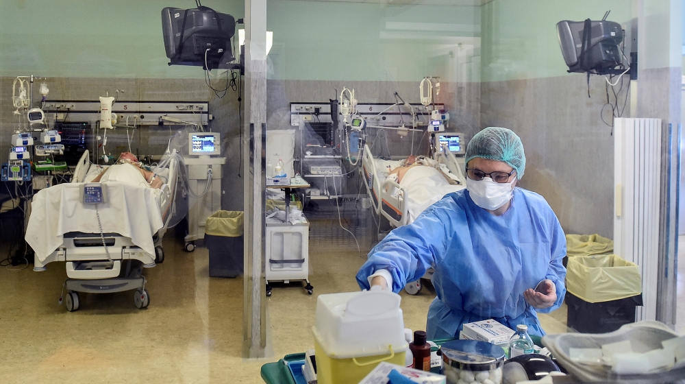A medical worker wearing a protective mask and suit treats patients suffering from coronavirus disease (COVID-19) in an intensive care unit at the Oglio Po hospital in Cremona, Italy March 19, 2020. R