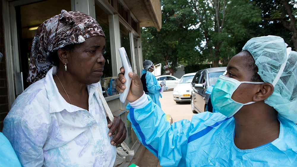 A woman is screened  by a Health worker before  visiting a  relative at a  public hospital  in Harare, Zimbabwe ,Saturday, March, 21, 2020 . Zimbabwe announced its first case of coronavirus,in one of 