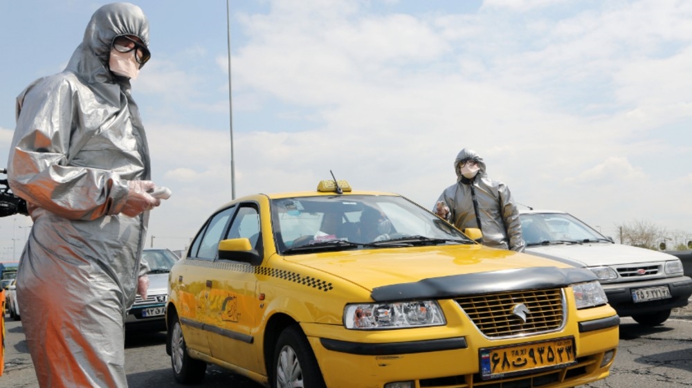 Coronavirus precautions in Iran- - TEHRAN, IRAN - MARCH 26: Health officials check body temperature of drivers and passengers at the entrance 