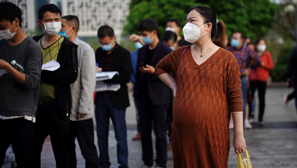 People wearing face masks line up outside Xianning Central Hospital in Xianning
