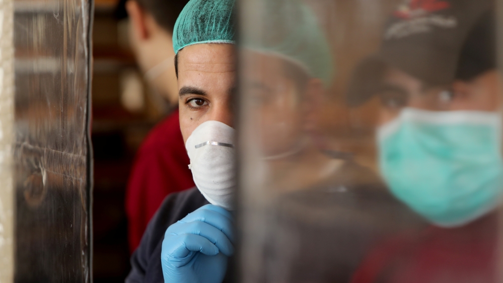 Palestinians, wearing masks as a preventive measure against the coronavirus disease, work in a bakery in Gaza City