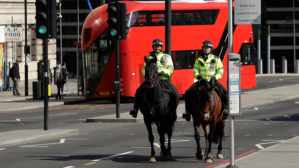 Two mounted police make their way over Westminster Bridge in London, Wednesday, March 25, 2020. British lawmakers will vote later Wednesday to shut down Parliament for 4 weeks, due to the coronavirus
