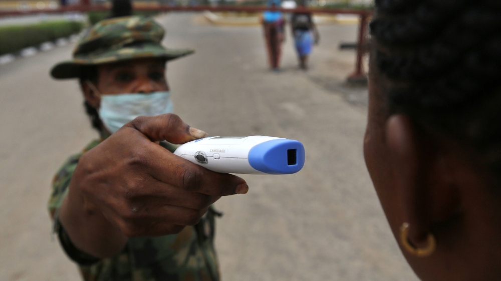 A member of the Nigerian army performs a temperature check on a visitor at the entrance of the Nigerian Army Hospital in the Yaba area of Lagos, Nigeria, on Friday, Feb. 28, 2020. Nigerian health auth