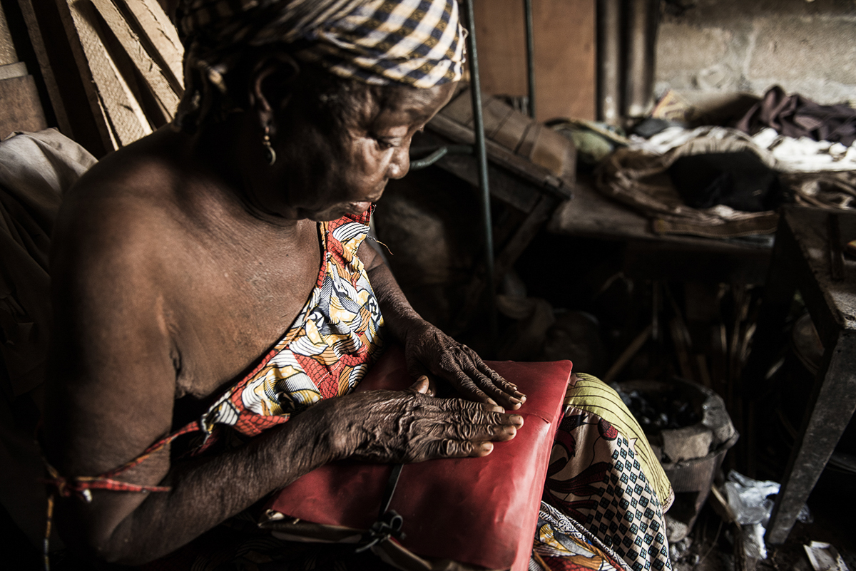 Thérèse Yambissi shows a folder containing documents from the Church, in which she is described as a good Catholic, in her house in Bangui. Thérèse was charged of witchcraft because of her age. She ig
