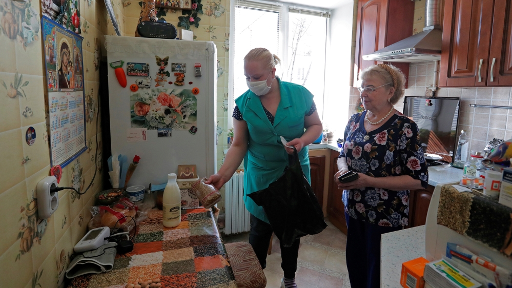 A social worker hands over the purchased food to a local resident amid coronavirus disease (COVID-19) outbreak in Minsk