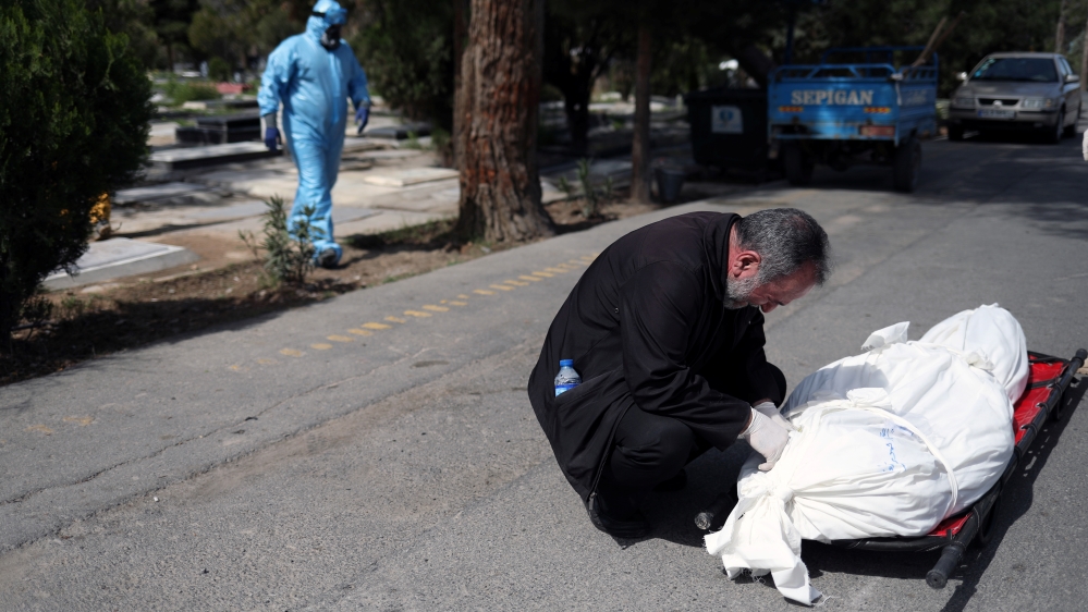 A relative reacts before the burial of the journalist Abdollah Zavieh, who passed away due to coronavirus disease (COVID-19), at Behesht Zahra cemetery in Tehran