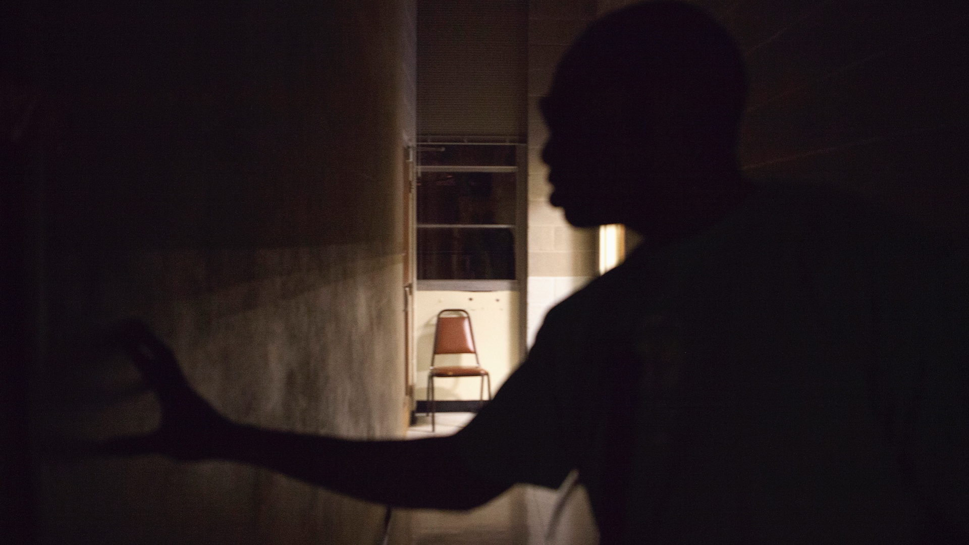 A man who is blind feels his way down a hallway in Little Rock, Arkansas