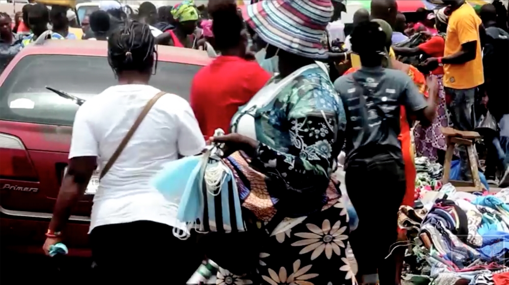 Woman selling masks in the market in Monrovia Liberia [Screen grab/ Reuters]