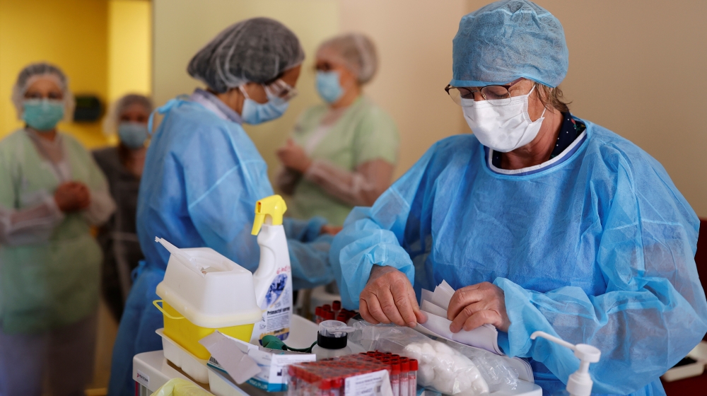 Laboratory staff, wearing protective suits and face masks, collect blood samples for serological tests on residents and employees of the La Weiss retirement home (EHPAD) in Kaysersberg, as the spread 