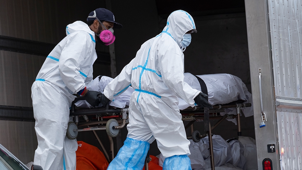 Workers move bodies to a refrigerated truck from the Andrew T. Cleckley Funeral Home in the Brooklyn borough of New York, Wednesday, April 29, 2020. Police responded to a report of human bodies in veh