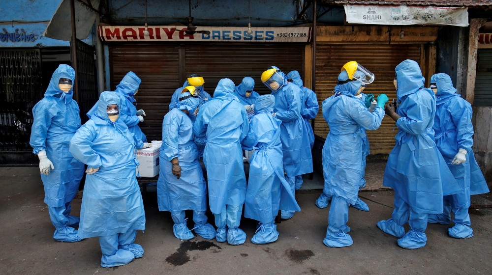 Doctors wearing protective gear gather to take swabs from the residents to test for coronavirus disease (COVID-19) at a residential area in Ahmedabad, India, April 8, 2020. REUTERS/Amit Dave