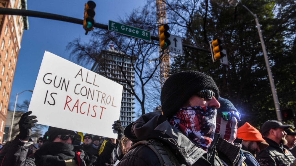 A protester holding a sign reading, “All gun control is racist” during a Gun Lobby Day in front of the Virginia State Capitol building in Richmond, Virginia, US on January 20, 2020