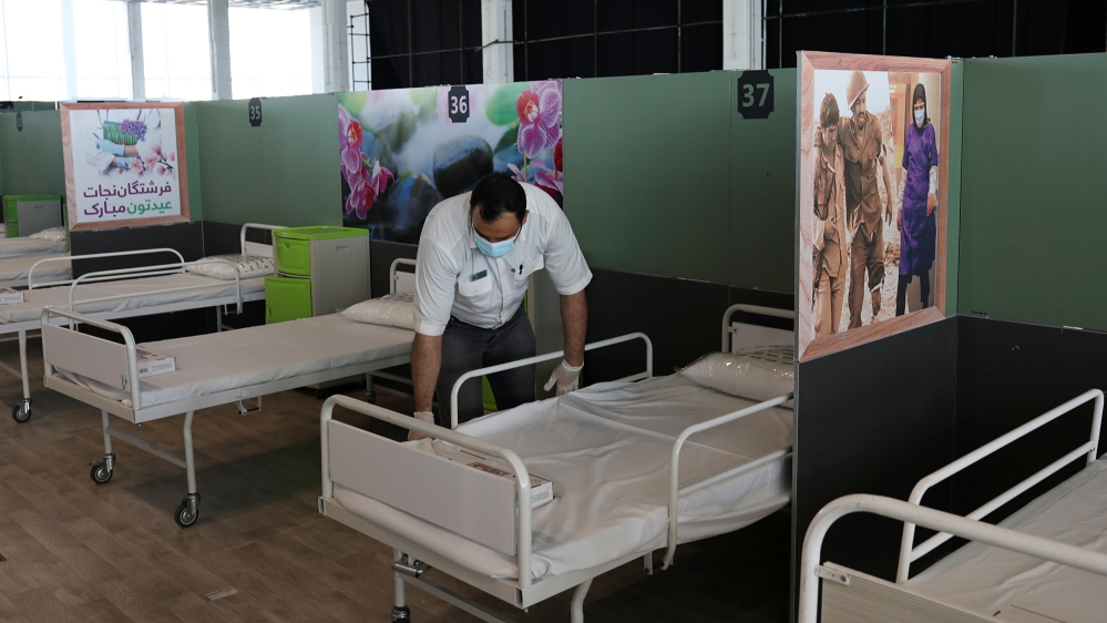 A medical aid worker sets up and installs a bed at a shopping mall, to receive patients suffering from the coronavirus disease (COVID-19), in Tehran