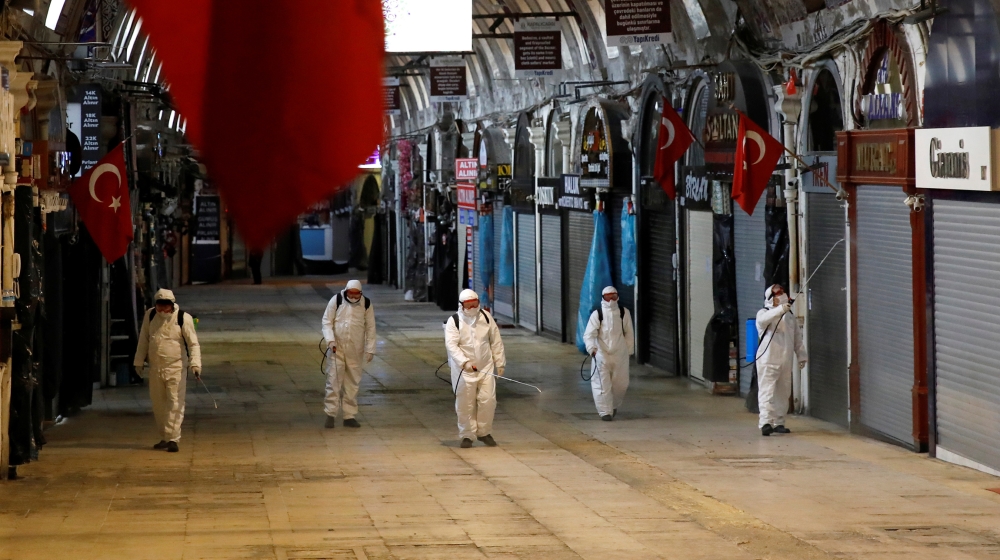 Workers in protective suits spray disinfectant at Grand Bazaar, known as the Covered Bazaar, to prevent the spread of coronavirus disease (COVID-19), in Istanbul, Turkey, March 25, 2020. REUTERS/Umit