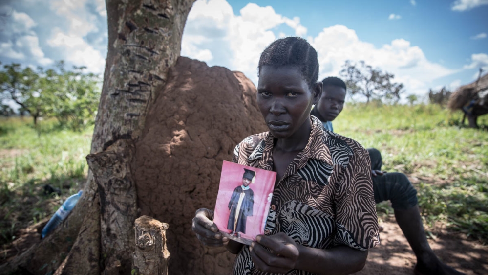 Jeanette Aromorach holds a picture of her son, 12-year-old Stewart Rubamga-Kwo, who died on March 31, unable to reach hospital because of Uganda''s transport ban. [Sally Hayden/Al Jazeera]