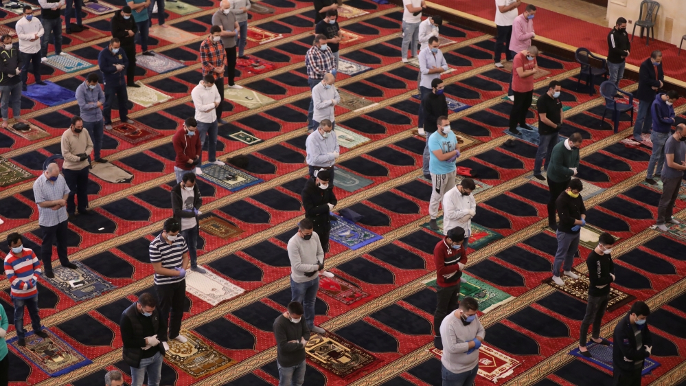 People pray as they wear face masks and practice social distancing as a preventive measure against the spread of the coronavirus disease (COVID-19) outbreak in Beirut