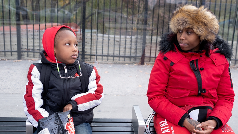 Still Here - Kamilah and Jeyson waiting for the bus [Sara Bennett/Al Jazeera]