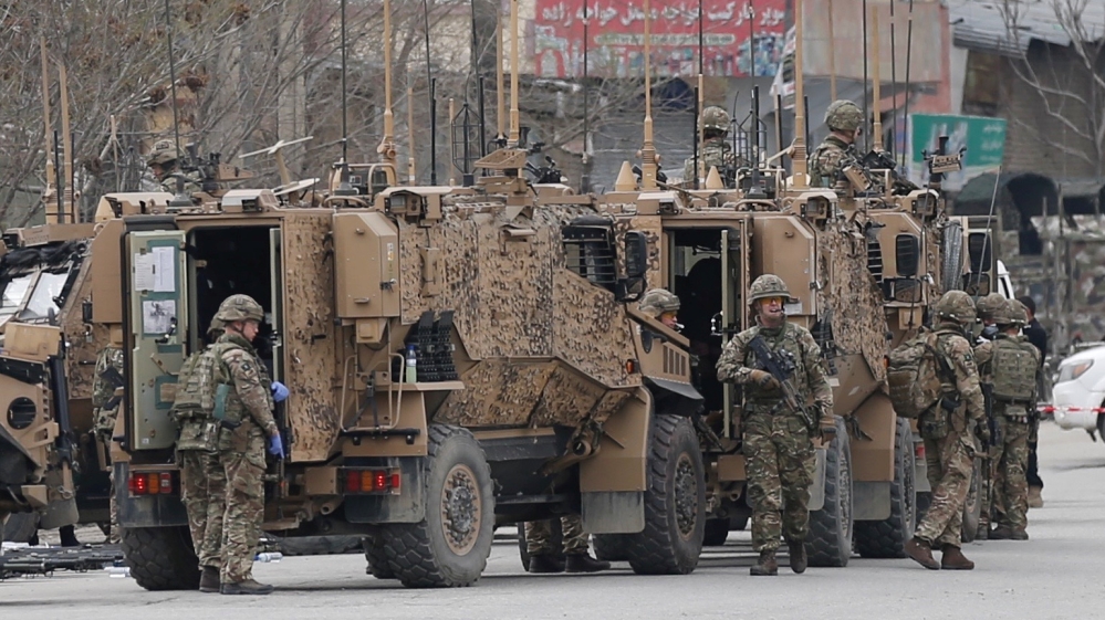 NATO soldiers inspect near the site of an attack in Kabul
