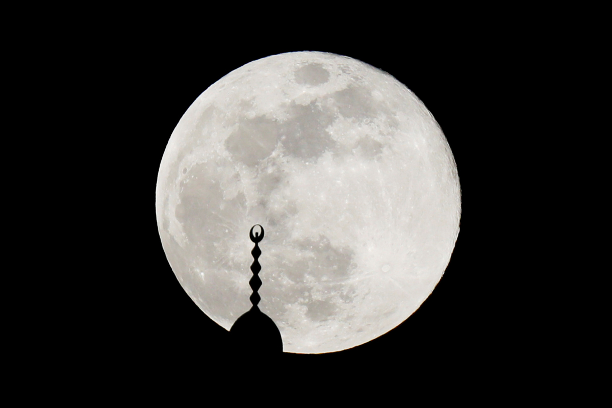 The full moon, also known as Supermoon or Flower Moon, rises over a mosque minaret on the 14th day of the holy fasting month of Ramadan, in Amman, Jordan May 7, 2020. REUTERS/Muhammad Hamed