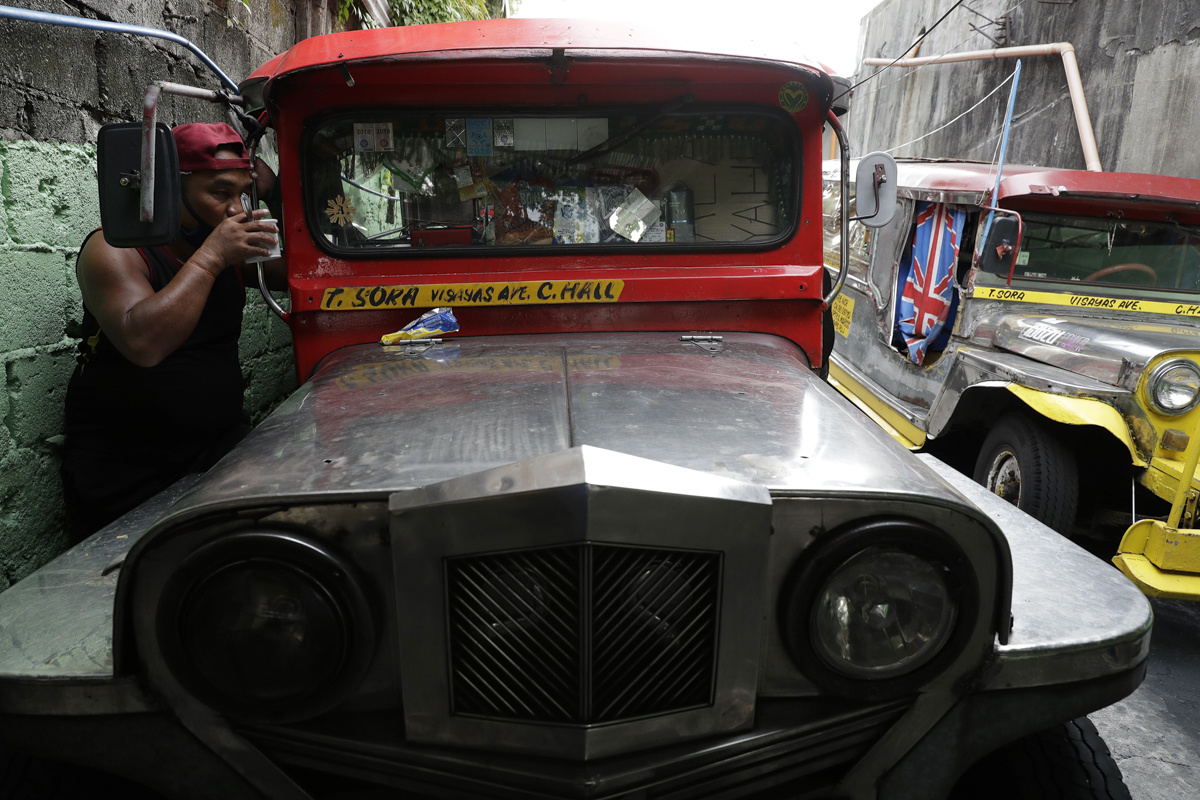 A jeepney driver drinks coffee beside his vehicle at the Tandang Sora terminal which have been home for them since a lockdown started three months ago, on Wednesday, June 17, 2020 in Quezon city, Phil