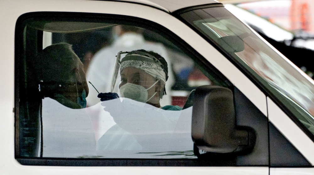 A coronavirus test is administered by a healthcare worker at a drive-thru coronavirus testing site hosted by Arlington County and the Commonwealth of Virginia in Arlington, Virginia, U.S., on Friday, 