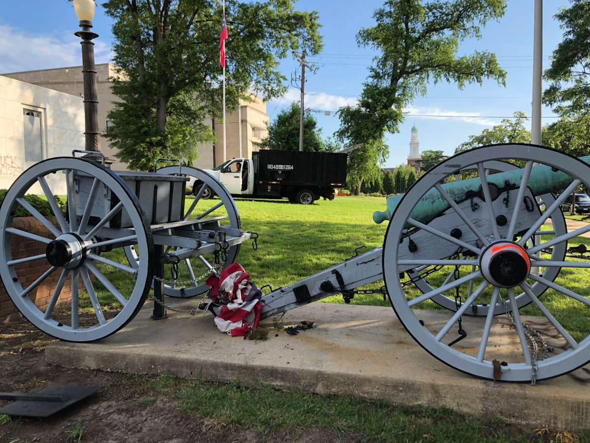 A tattered American flag lays on the ground on the property of the United Daughters of the Confederacy headquarters Sunday, May 31, 2020, in Richmond, Va. The building was covered in graffiti, some wi
