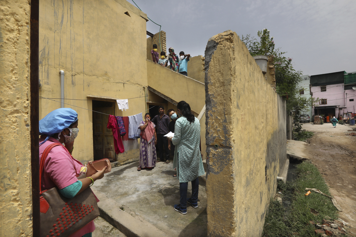 An Indian government school teacher takes a survey at a residential neighbourhood in New Delhi, India, Saturday, June 27, 2020. A massive survey to take down health details of New Delhi''s entire popul