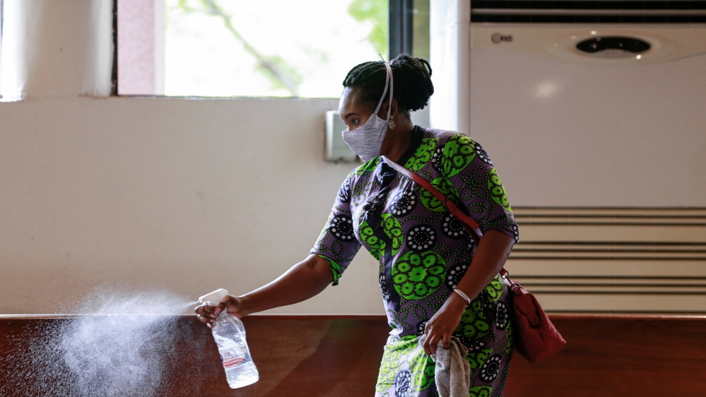A worker sprays disinfectant on the chairs, after a church service as worship centers were reopened following the ease of restrictions imposed to curb the spread of the coronavirus disease in Abuja