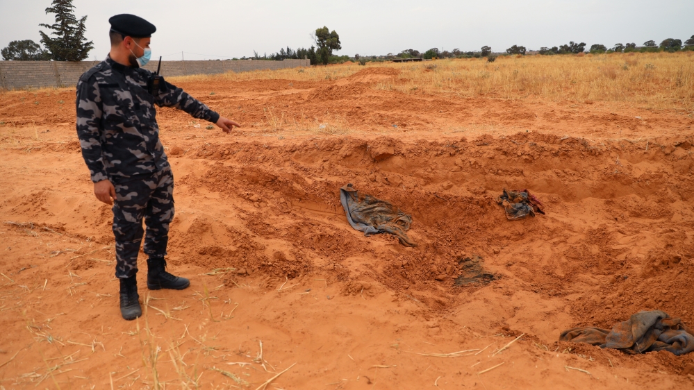 A member of security forces loyal to Libya''s internationally recognised government points to a mass grave, according to Libya''s Internationally recognised government officials, in Tarhouna city