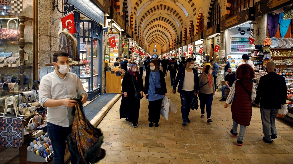 People wearing protective face masks walk at the spice market, also known as the Egyptian Bazaar, as it reopens after weeks of the close doors amid the spread of the coronavirus disease (COVID-19), in