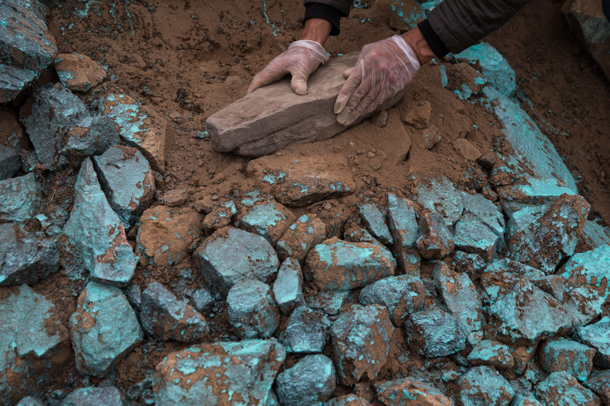 A relative decorates with rocks the tomb of Adrian Tarazona Manrique, 72, who died from COVID-19 complications, at the Nueva Esperanza cemetery on the outskirts of Lima, Peru, Thursday, May 28, 2020.