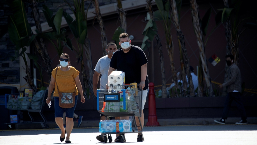 Shoppers wearing face masks are pictured in the parking area of a Walmart Superstore