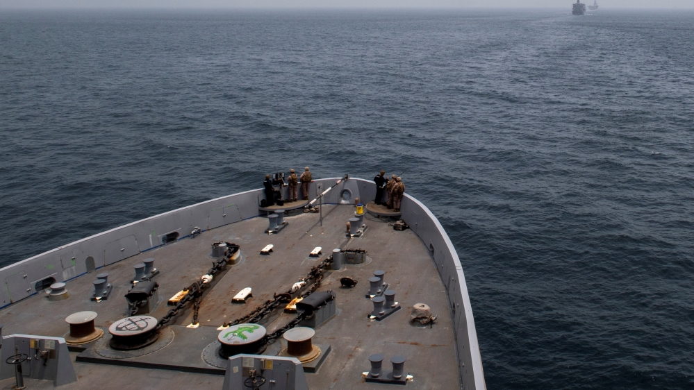 The amphibious transport dock ship USS John P. Murtha is seen behind the fleet replenishment oiler USNS Tippecanoe (T-AO 199) and amphibious assault ship USS Boxer as it transits the Strait of