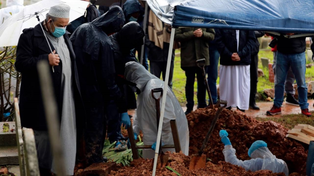 Undertakers wearing personal protective equipment exit the grave of Shaykh Seraj Hassan Hendricks of Azzawia Institute during his funeral in Cape Town on Friday