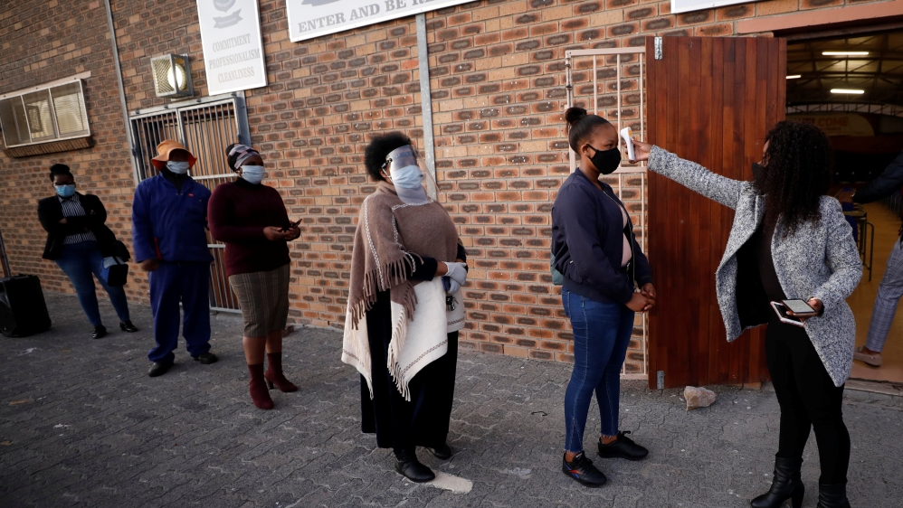 Teachers practice social distancing before being screened as schools begin to reopen after the coronavirus disease lockdown in Langa township in Cape Town, South Africa