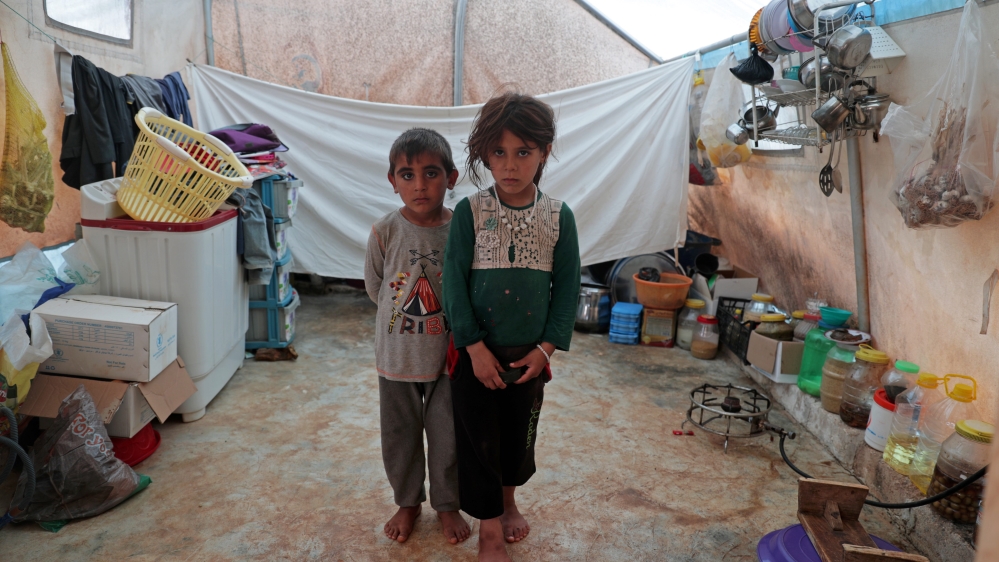 Jumana and Farhan al-Alyawi, 8-year-old displaced Syrian twins from east Idlib, pose for a picture in a tent at Atmeh Camp