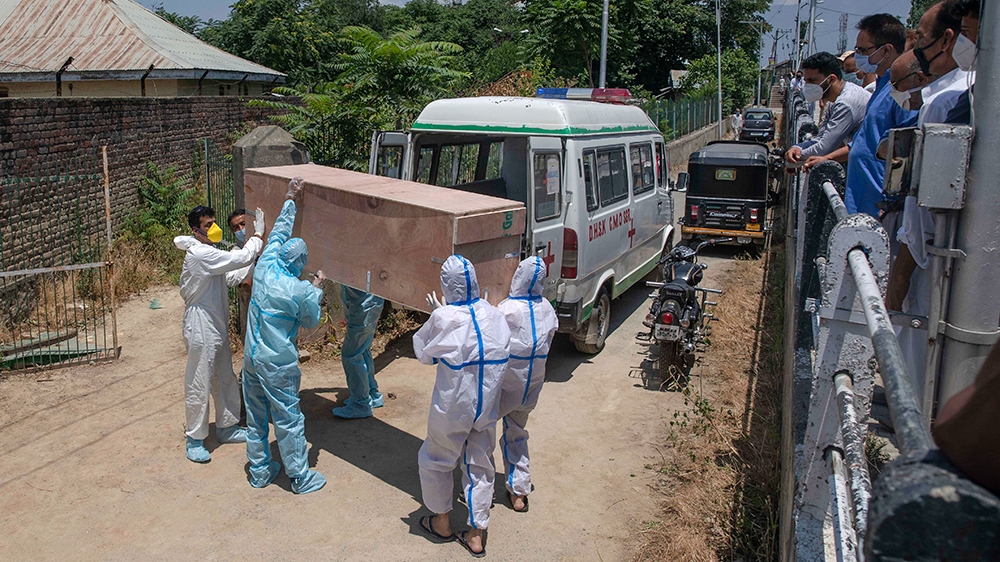 Relatives carry the body of a Kashmir man who died of COVID-19 for burial at a cemetery in Srinagar
