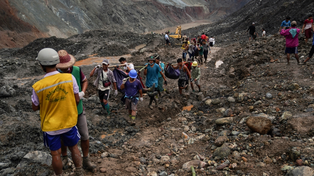 Rescuers recover bodies near the landslide area in the jade mining site in Hpakhant in Kachin state on July 2, 2020. The battered bodies of more than 120 jade miners were pulled from a sea of mud afte