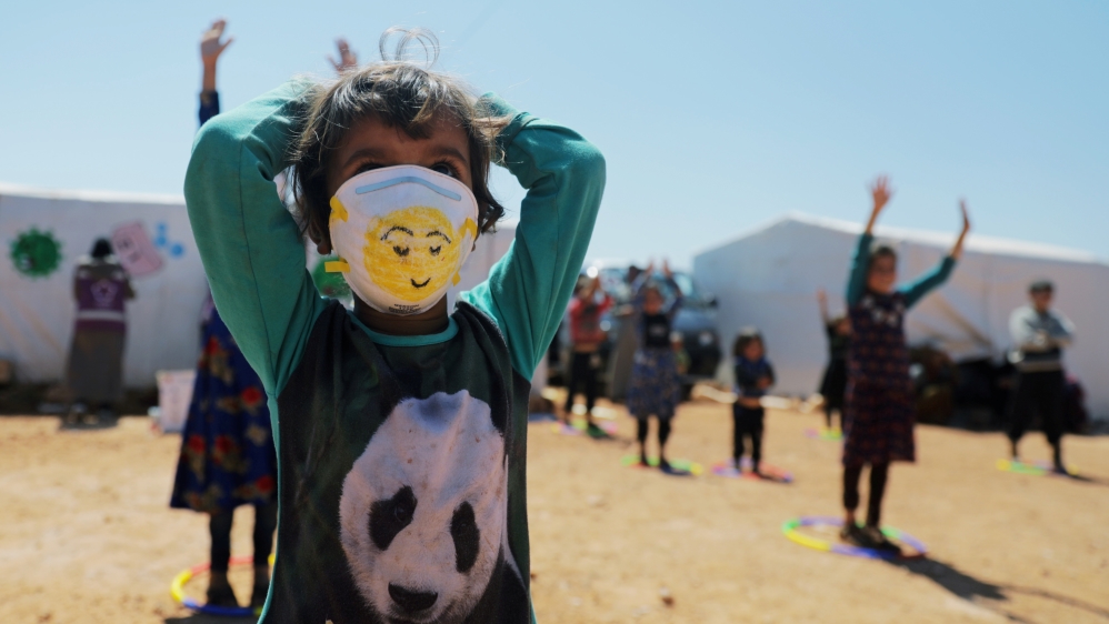 A displaced girl wears a face mask as she takes part in an event organzied by Violet Organization