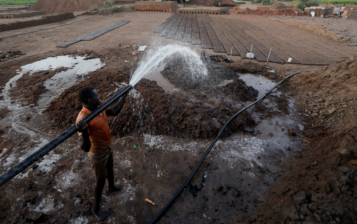 Zaki El-Dine, 24, a brick-maker, pours water from the Nile river onto a patch of mud to make bricks on Tuti Island, Khartoum, Sudan, February 12, 2020. REUTERS/Zohra Bensemra SEARCH "BENSEMRA NILE