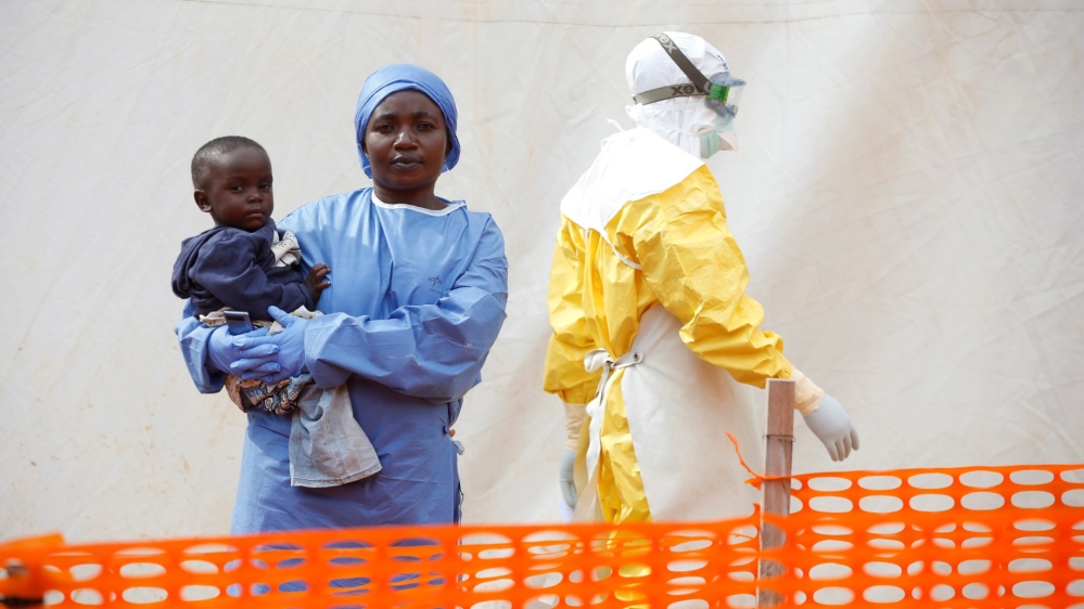 FILE PHOTO: Mwamini Kahindo, an Ebola survivor working as a caregiver to babies who are confirmed Ebola cases, holds an infant outside the red zone at the Ebola treatment centre in Butembo, DRC, 2019